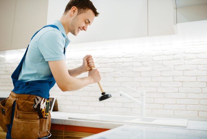 male-plumber-in-uniform-holds-plunger-clog.jpg